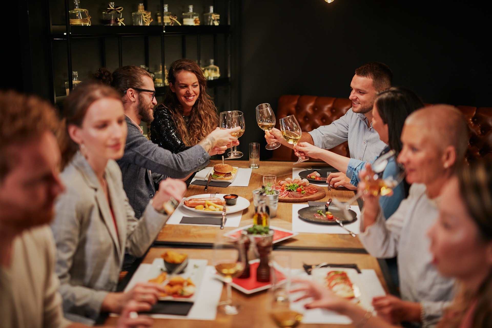 Group of best friends sitting in restaurant, having dinner, drinking wine and having fun.